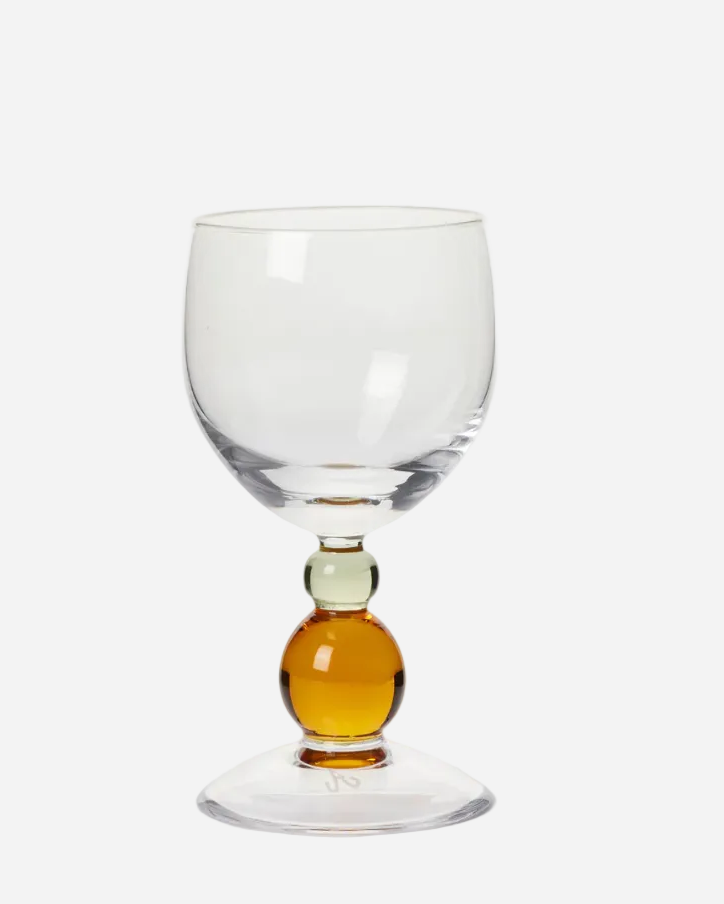 Clear glass with a small amount of amber liquid at the base on a white background